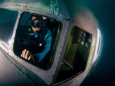 A diver enjoys the cockpit of the first sunken Dakota