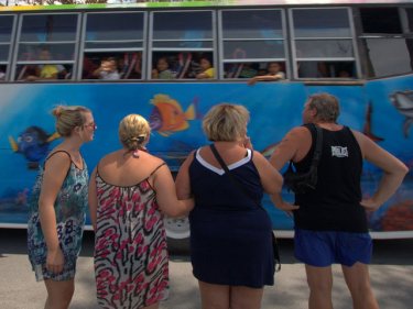 These tourists in Patong were cheered by a wave from a passing bus