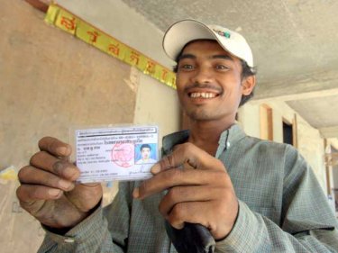 A Burmese construction worker shows his Phuket ID card