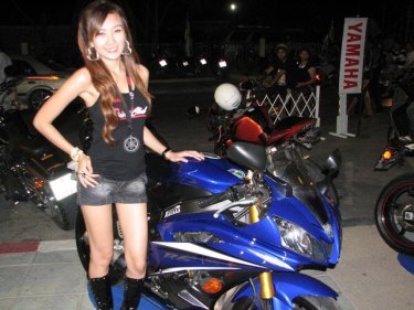 A ''pretty'' shows off a motorcycle. The girls are expensive extras