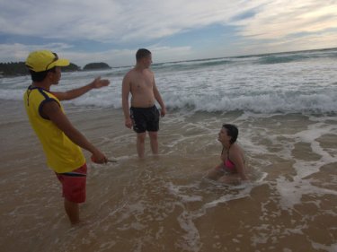 A lifeguard tries to persuade tourists to leave the water after a drowning