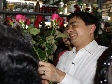Roses for the PM as he tours a Phuket market on Saturday