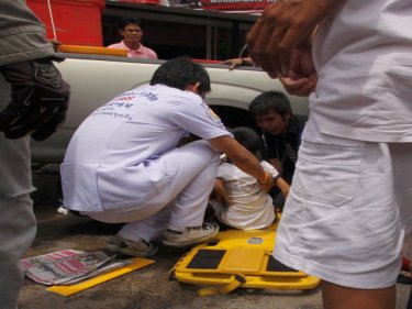 A young boy sits injured on a Phuket street after a hit-run