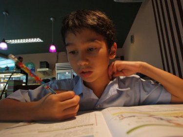 Homework in a Patong restaurant for back-on-Phuket boy Ricardo