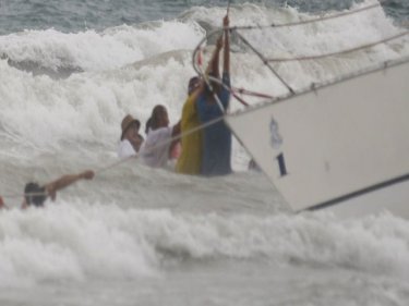 Crew fight surf and a raging wind to right a beached yacht on Phuket