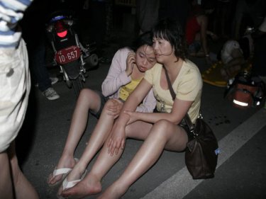 Two bus passengers await attention after the crash on Phuket