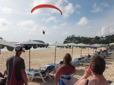 A paraglider lands on Phuket's Kata Noi beach on Monday