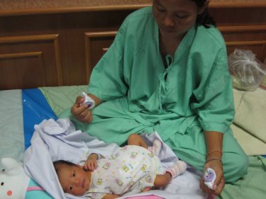 A Burmese mother tends her newborn child at a Phuket hospital