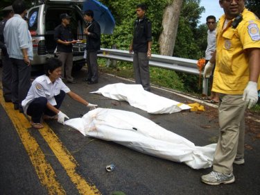 Police and volunteers recover the two bodies on a quiet Phuket coast road