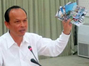 Vice Governor Somkiet Sangkaosutthirak  waves photo evidence