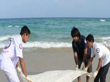 Rescue foundation workers cover the body on Karon beach today