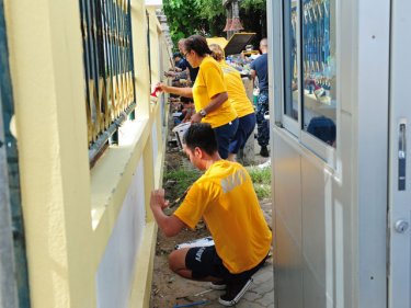 Volunteers, including sailors from USS Pinckney, brighten the school