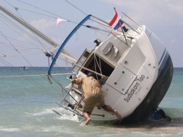 All aboard . . . the owner of a beached yacht jumps on as his boat escapes