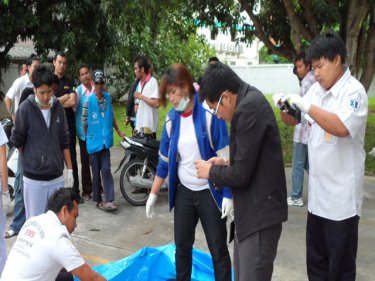 Paramedics and forensic police examine the Patong car park