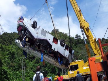 The crashed bus is lifted back to the roadway from the Phuket jungle