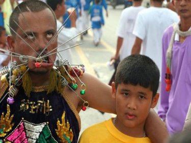 Father and son team up for a traditional street parade on Phuket
