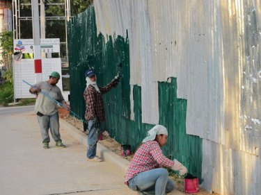 Workers paint the camp perimeter fence in Phuket City yesterday