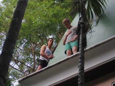 A friend tries to talk down a young tourist on a resort ledge today