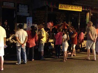 A crowd gathers as Phuket police raid a Russian massage parlor