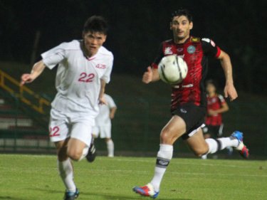 A North Korean side in white takes on the emerging Phuket FC team