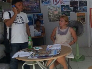 An officer quizzes Russian Natalie Nikitolova, 30, in the Phuket shop