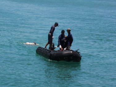 The body of the unidentified man is towed back to Phuket today
