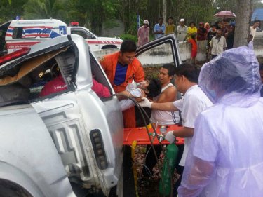 An injured man is removed after a crash near Krasom, in Phang Nga, north of Phuket. One person later died in hospital