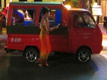 A tourist pays a tuk-tuk driver in the Kata-Karon area near Dino Park