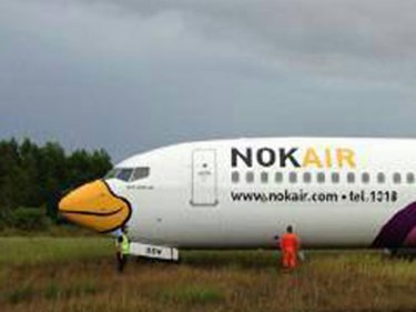 Still smiling: the Nok Air flight comes to rest in the green grass of home
