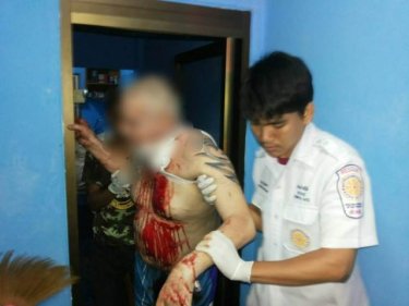 The wounded man is escorted to a waiting ambulance in Patong last night