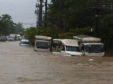 Vans are swamped as a heavy downpour triggers floods in Phuket