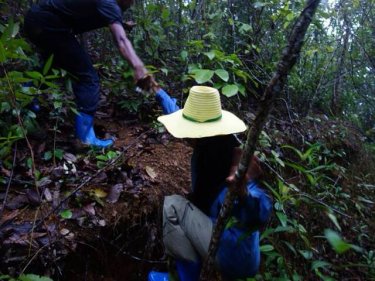 A Phuketwan journalist being assisted through the jungle near a secret camp