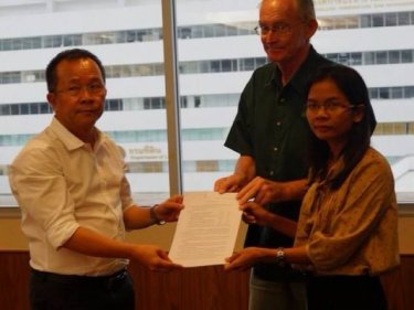 Phuket reporters Alan Morison and Chutima Sidasathian present documents to Human Rights Commissioner Dr Niran Pitakwatchara