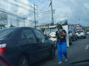 A vendor sells new homes to travellers stuck in traffic at a Phuket intersection