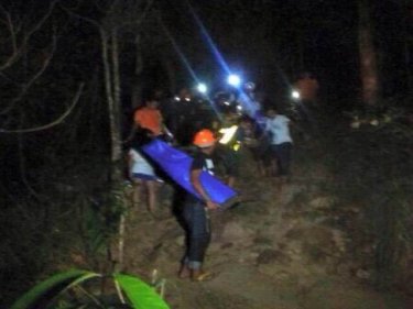 Rescuers bring out the two men on Samui. One died in hospital later