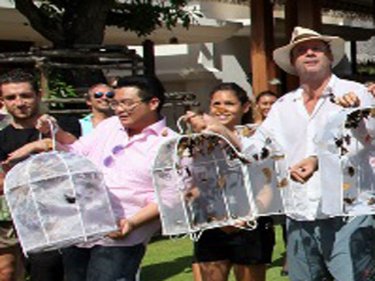 Johan Hansen (in hat) helps to free butterflies at the BB Resort opening
