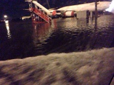 Water laps across the tarmac at Don Muang Airport after a second storm