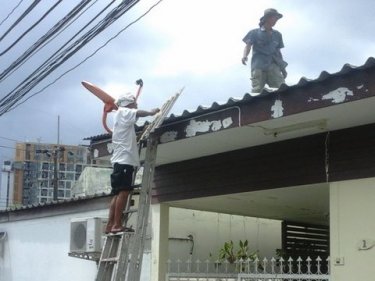 Roofers work in advance of storm clouds Phuket hopes will bring rain