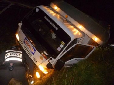 Police inspect the crashed truck on Phuket's hilly coast road last night