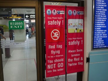 Subdued swim warning signage at Phuket airport fails to impress. If authorities were serious, the message would be on a large billboard