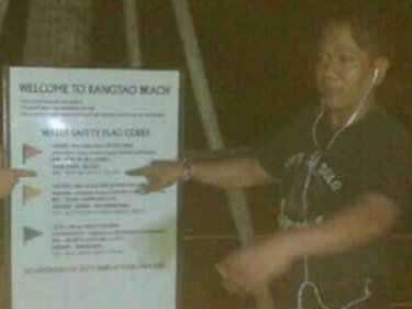 An official points to a warning sign at Phuket's Bang Tao beach last night
