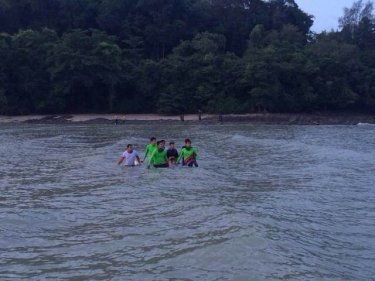 Rescuers carry the boy back to shore on eastern Phuket yesterday