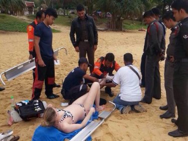 Lifeguards treat the woman at Karon beach today after the 'bite'