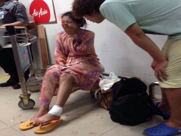 A bystander consoles the injured tourist at Phuket airport tonight