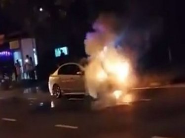 The taxi in flames on the road to Patong Hill last night