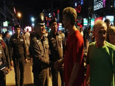 The present Superintendent of Kathu Police Station greets tourists last night during a drill in Soi Bangla aimed at highlighting safety in Patong