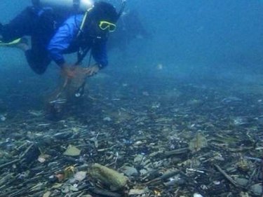 A diver floats over the trash cache off Phuket's Karon beach