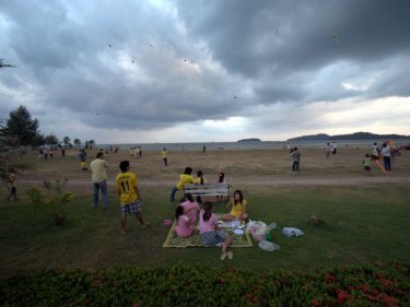 Well-wishers in pink and yellow celebrate the King's Birthday with kite-flying and picnics at Saphan Hin.