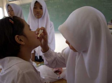Muslim and Buddhist classmates enjoy making up during a break at a Phang Nga school