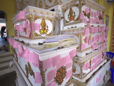 Coffins for the poor at a charity foundation on Phuket, carrying merit-making coupons for Songkran, the Thai New Year. The container dead are likely to be buried as paupers in similar coffins in Ranong.